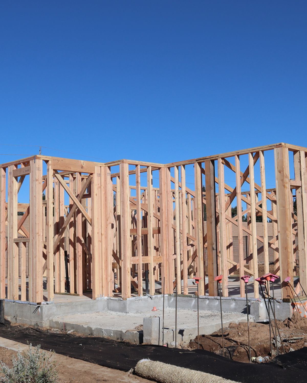 New home addition framed in lumber against a clear sky